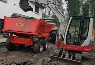 Digger emptying waste into trailer